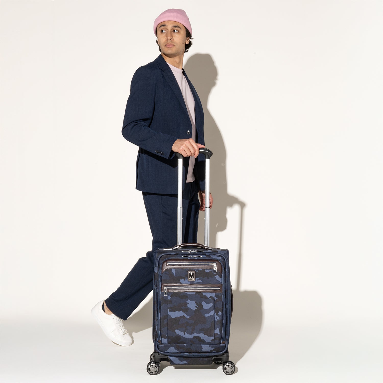 Traveler standing with the Travelpro Platinum Elite Carry-On Expandable Spinner in Camouflage