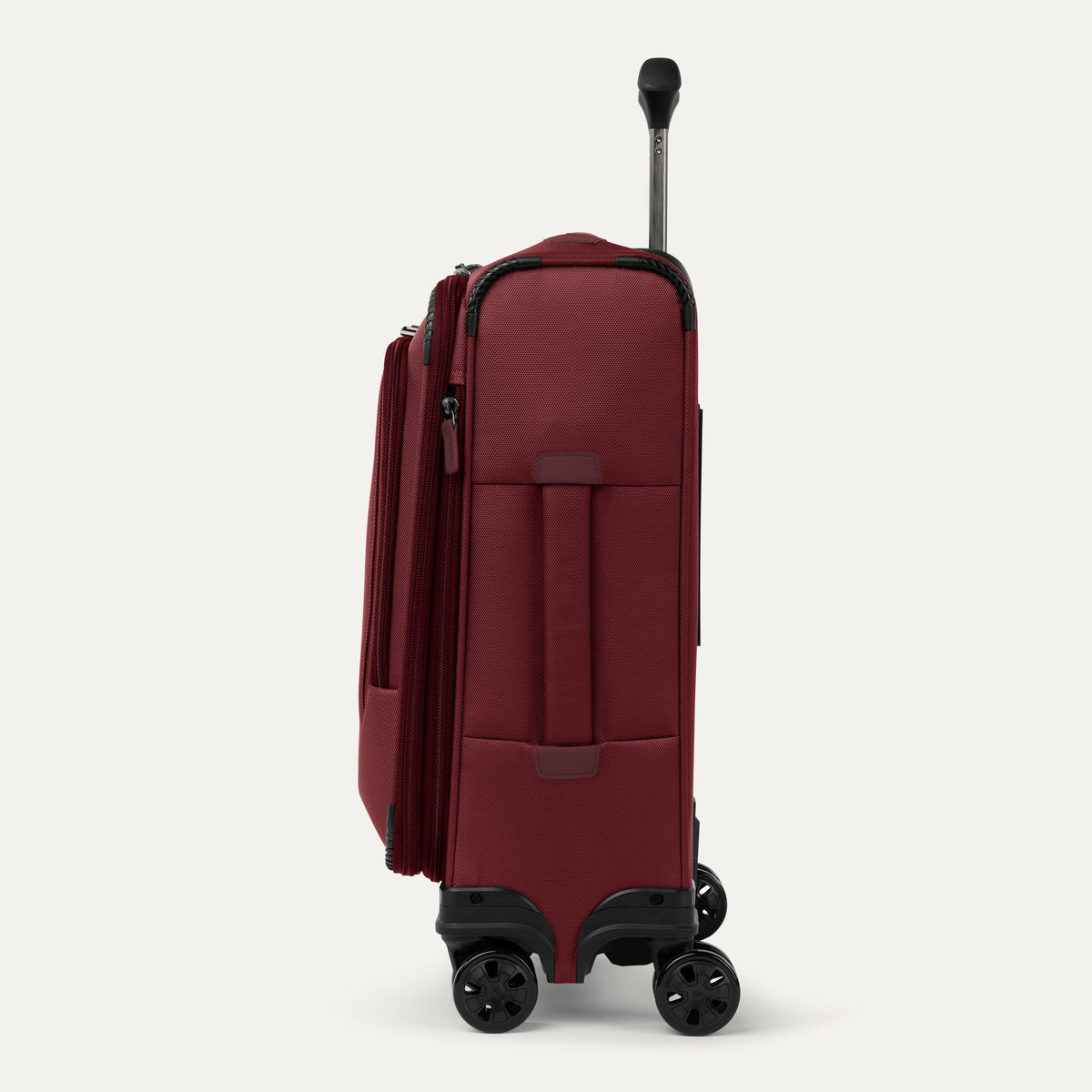 Side view of red suitcase with handle and wheels on a white a background 