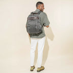 Person wearing a vintage grey business backpack on a white background