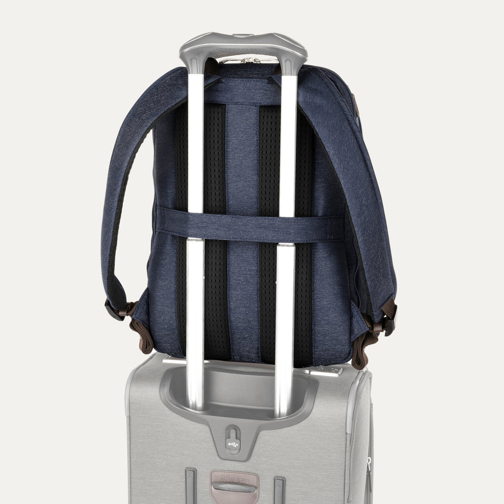True navy backpack with a rear strap over suitcase handle on a white background