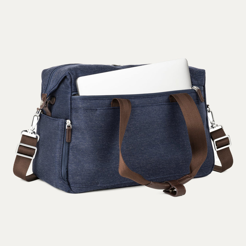 True navy tote with a laptop in the padded sleeve compartment on a white background 