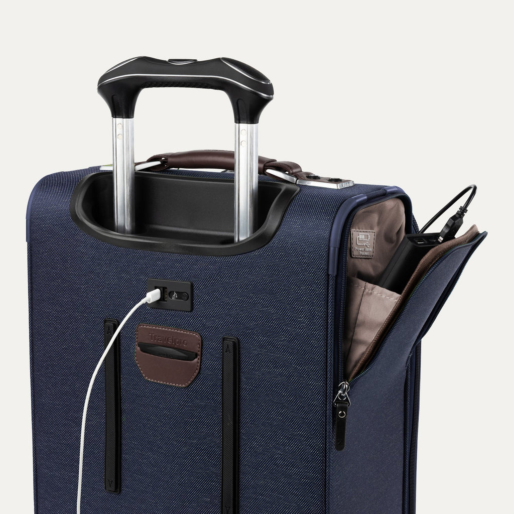 Close-up of blue suitcase with extended handle and visible USB charging cable, on white background