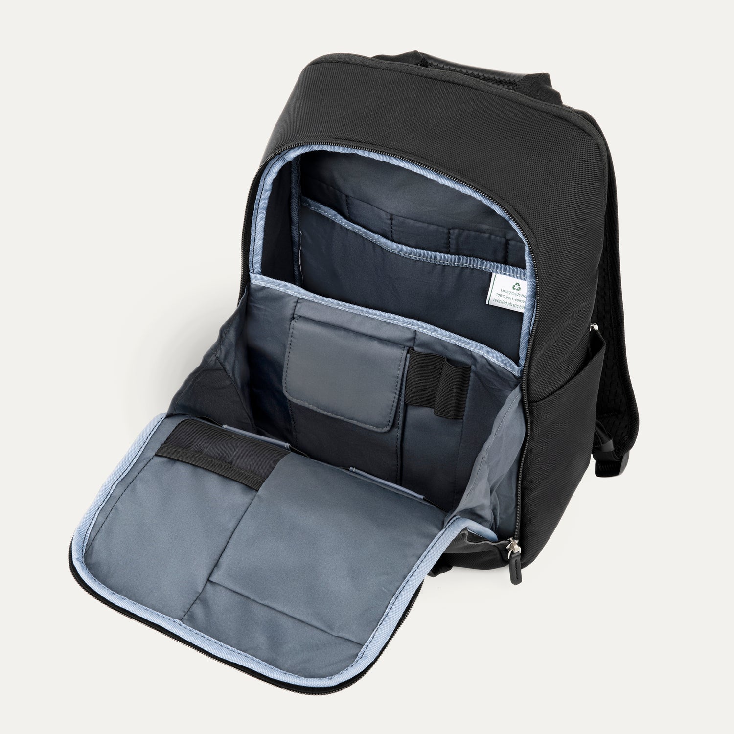 Open front compartment of a black backpack on a white background 