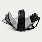 Black backpack with all the compartments open on a white background 
