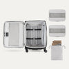 Open suitcase with packing accessories on a white background
