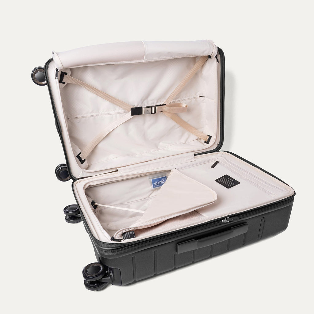 Open interior of the Medium Check-In from the Travelpro Platinum Reserve Compact Carry-On / Medium Check-In Hardside Set in Black Dust with hold-down straps