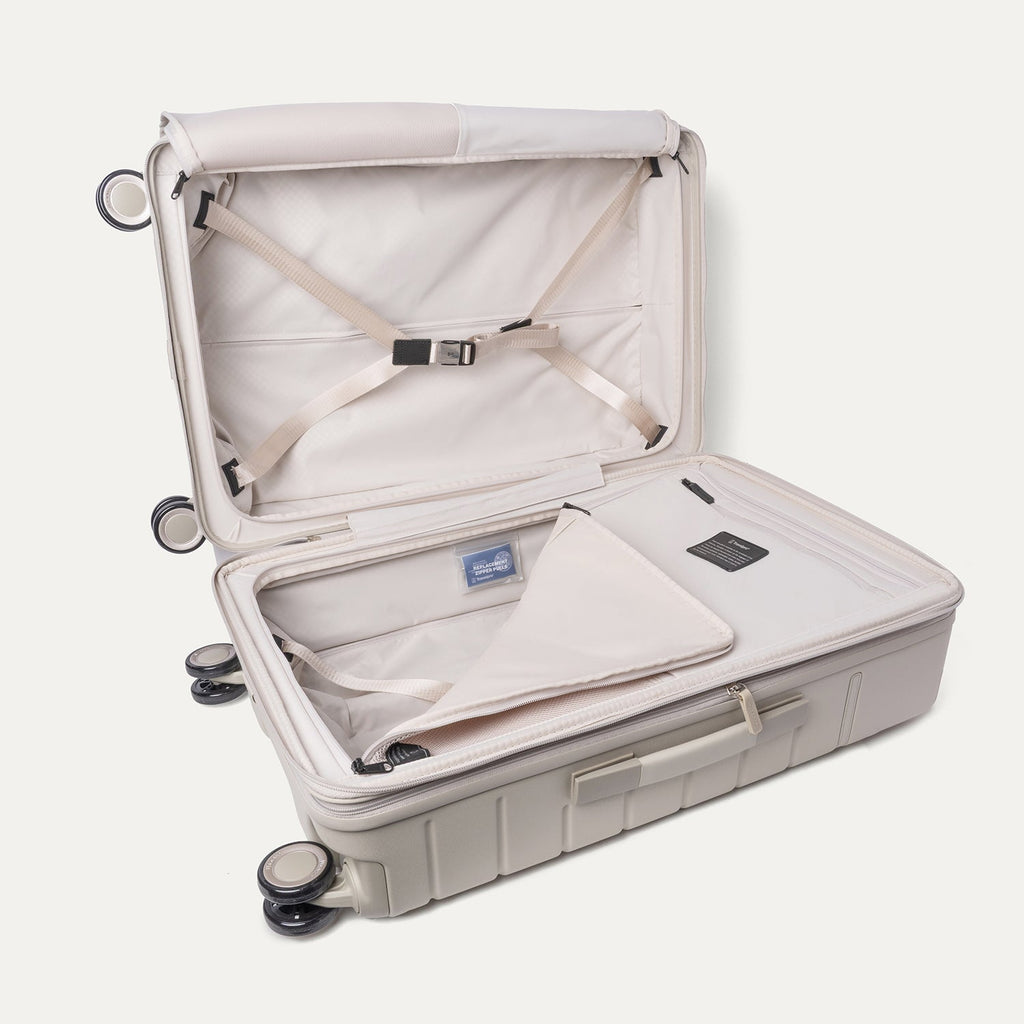 Open interior of the Medium Check-In from the Travelpro Platinum Reserve Compact Carry-On / Medium Check-In Hardside Set in Sandstone with hold-down straps