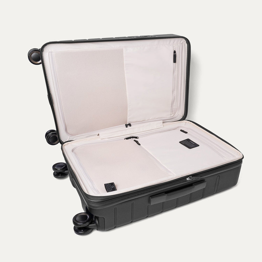 Open interior of the Medium Check-In from the Travelpro Platinum Reserve Compact Carry-On / Medium / Large Hardside Set in Black Dust showing the zippered divider panel