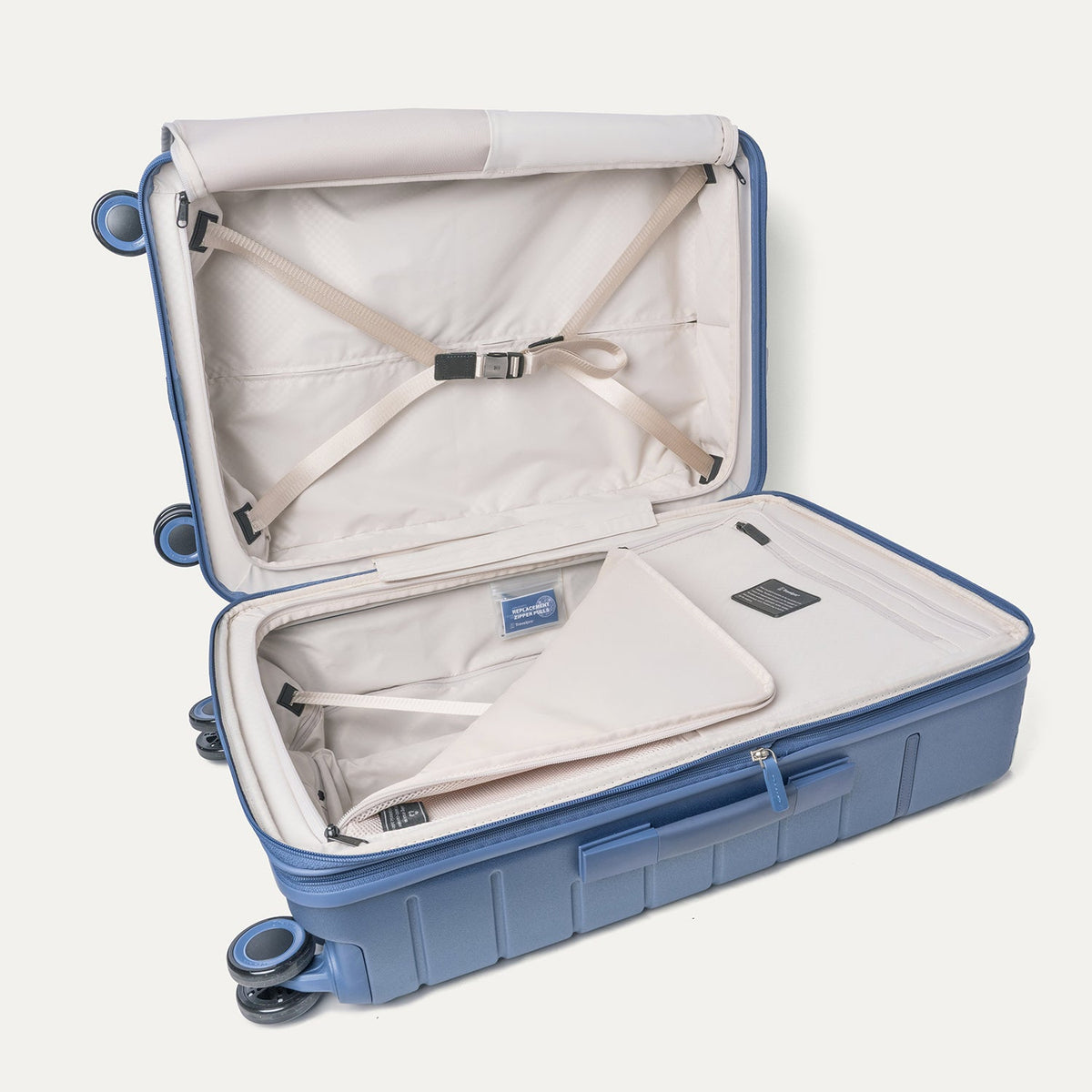 Open interior of the Medium Check-In from the Travelpro Platinum Reserve Compact Carry-On / Medium / Large Hardside Set in Steel Blue with hold-down straps