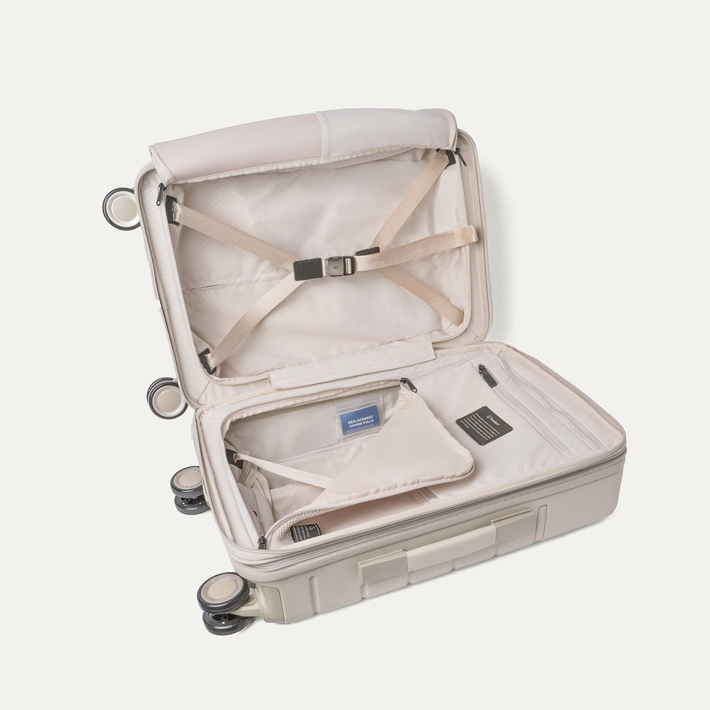 Open interior of the Compact Carry-On from the Travelpro Platinum Reserve Compact Carry-On / Medium / Large Hardside Set in Sandstone with hold-down straps