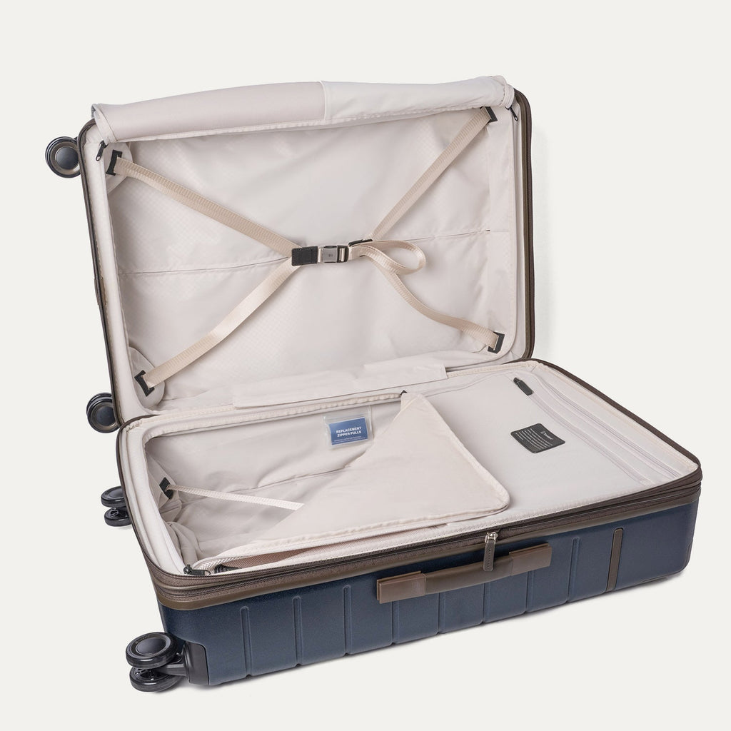Open interior of the Large Check-In from the Travelpro Platinum Reserve Compact Carry-On / Medium / Large Hardside Set in Midnight Trail with hold-down straps