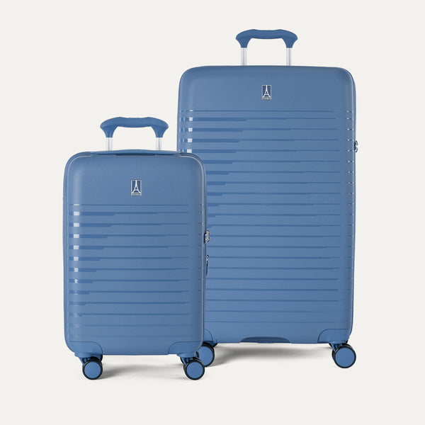 Two blue suitcases of different sizes on a light gray background