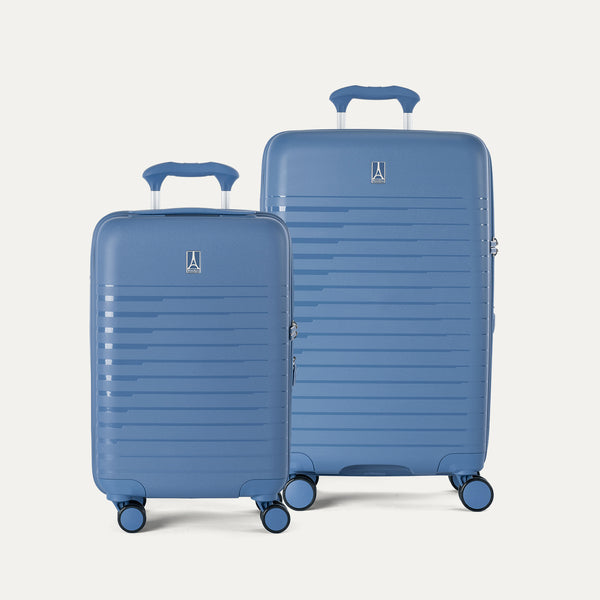 Two blue suitcases of different sizes on a light gray background