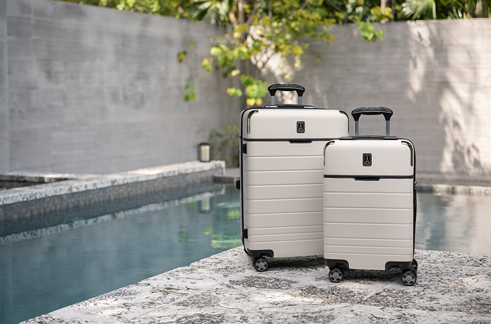 two white hardside suitcases next to each other by the pool